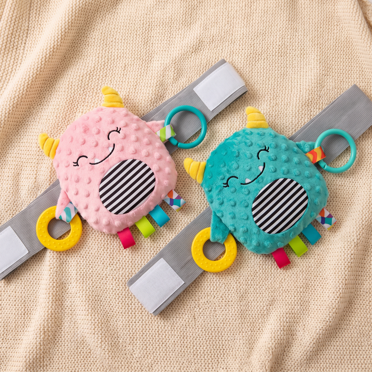 TummyHush Snuggle Monster in both colorways — pink and teal, side by side