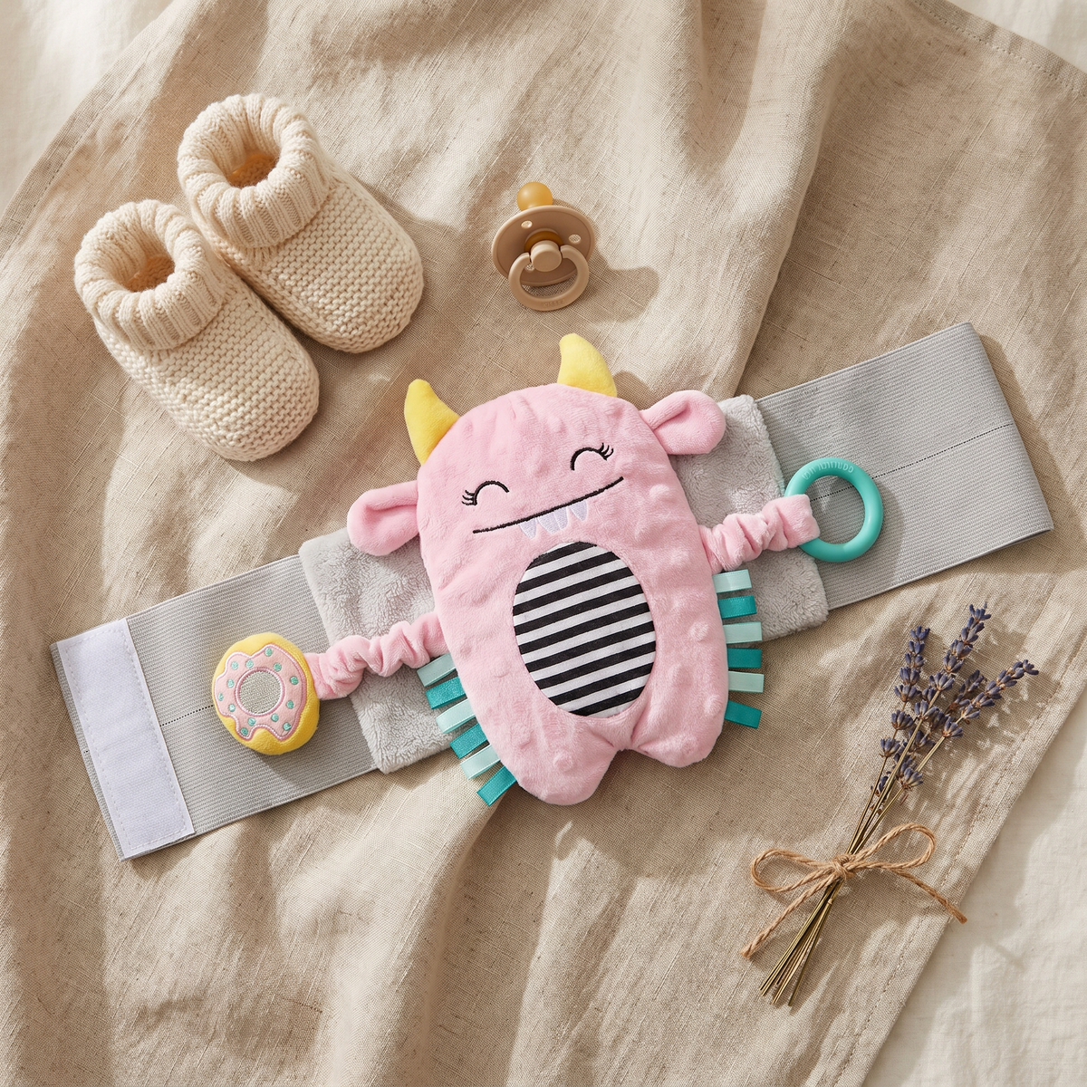 Snuggle Monster band flat lay with knitted baby booties, pacifier and lavender